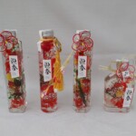 お正月向けにタッセルや水引飾りをワンポイントに赤を基調に仕上げた商品。