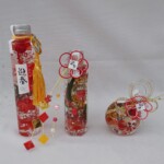 お正月向けにタッセルや水引飾りをワンポイントに赤を基調に仕上げた商品。